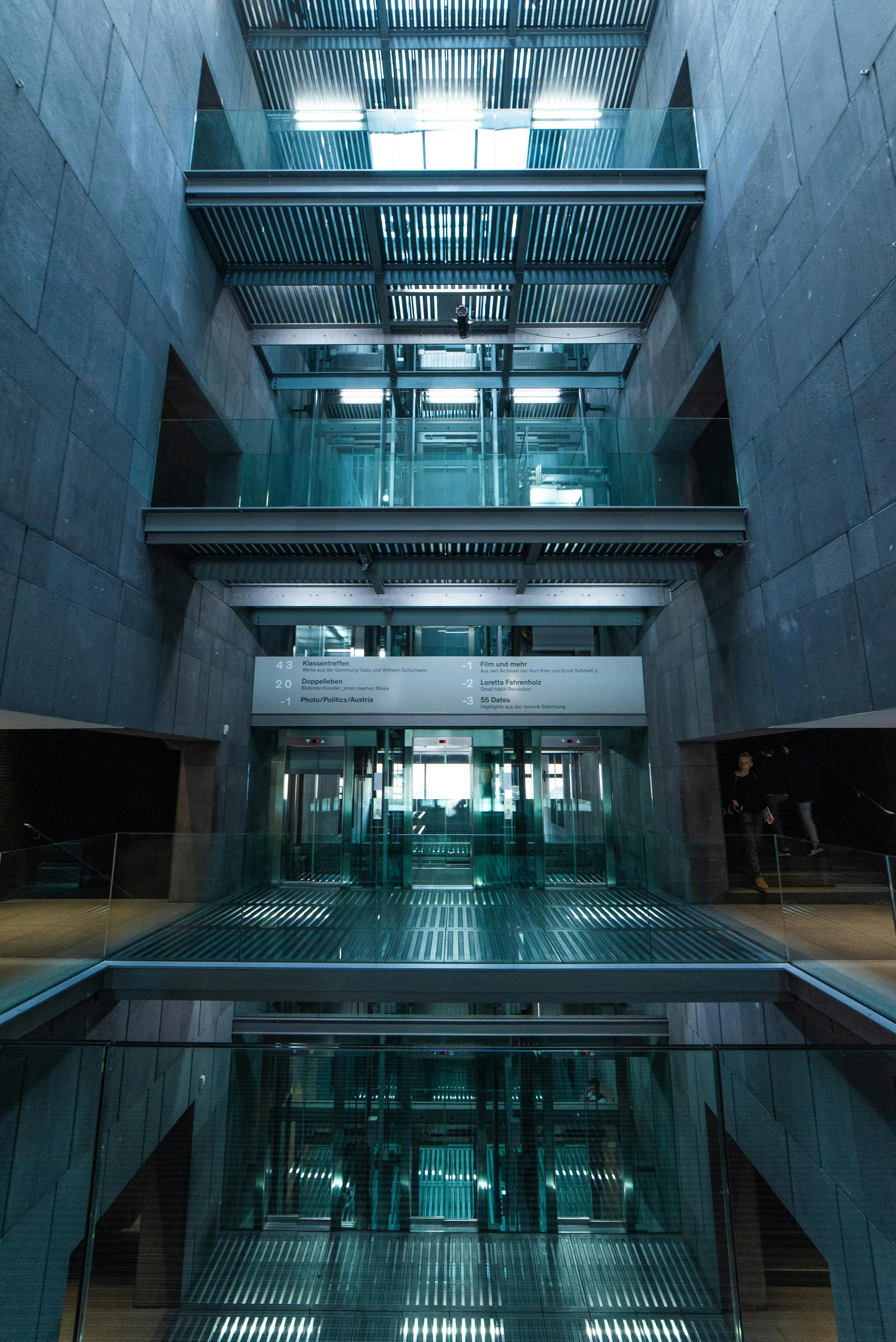 Vue intérieure d'un grand atrium avec ascenseurs panoramiques vitrés sur plusieurs niveaux