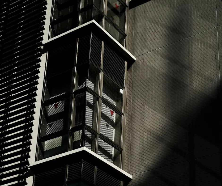 Gaine d'ascenseur panoramique vitrée en saillie sur la façade d'un immeuble de bureaux