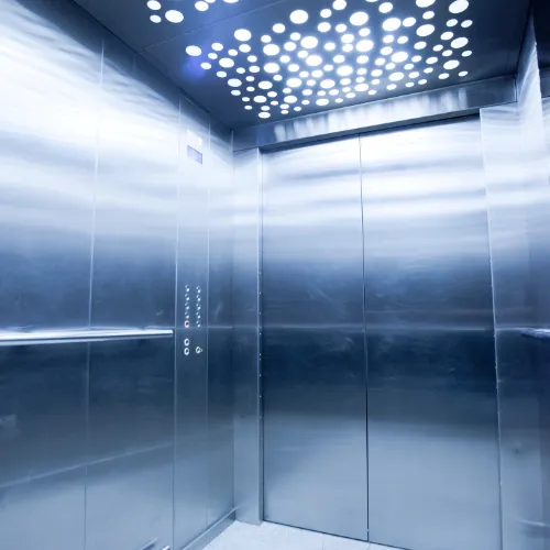 Intérieur d'une cabine d'ascenseur en acier brossé avec plafond à spots LED circulaires